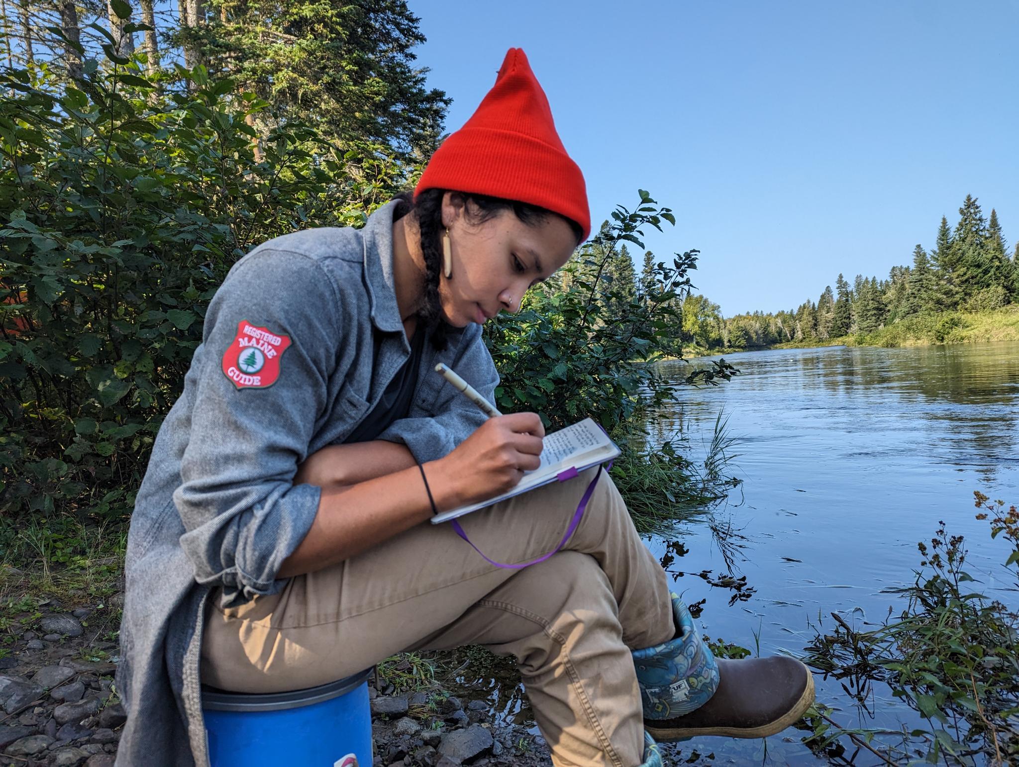 Tessa Storey, Registered Maine Guide, on the bank of an Aroostook County river.